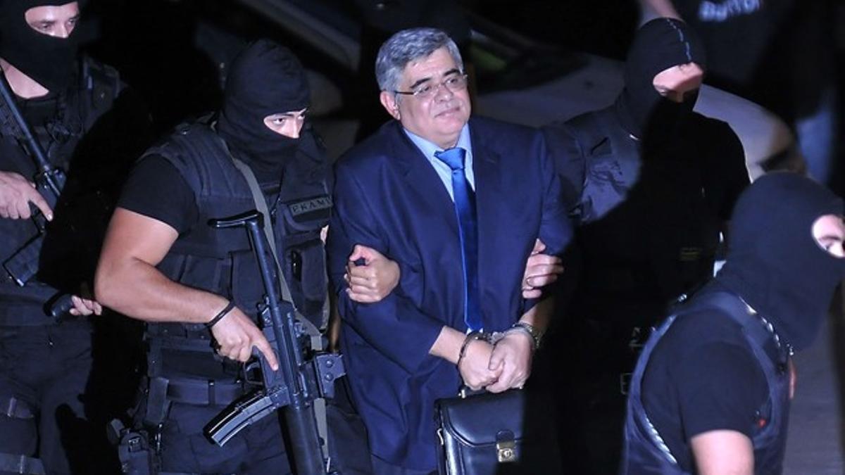 El líder de Amanecer Dorado, Nikolaos Mijaloliakos, llega a los juzgados escoltado por la policía, el miércoles en Atenas.