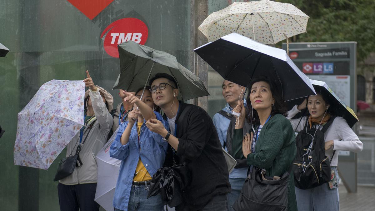 Barcelona. 27.08.2023. Barcelona. Turistas en los alrededores de la Sagrada Familia protegidos con sus paraguas de la lluvia, el día que ha descendido la temperatura tras una semana de ola de calor. ( mal tiempo, paraguas, frío). Fotografía de Jordi Cotrina