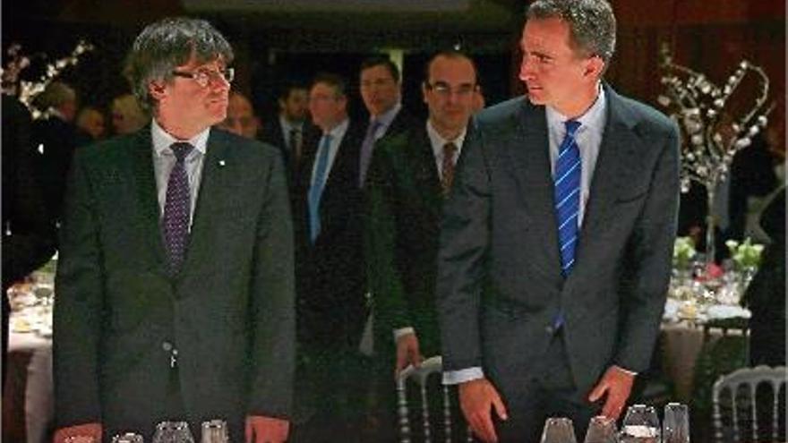 El president de la Generalitat, Carles Puigdemont, i el rei Felip VI, abans de seure a la taula.