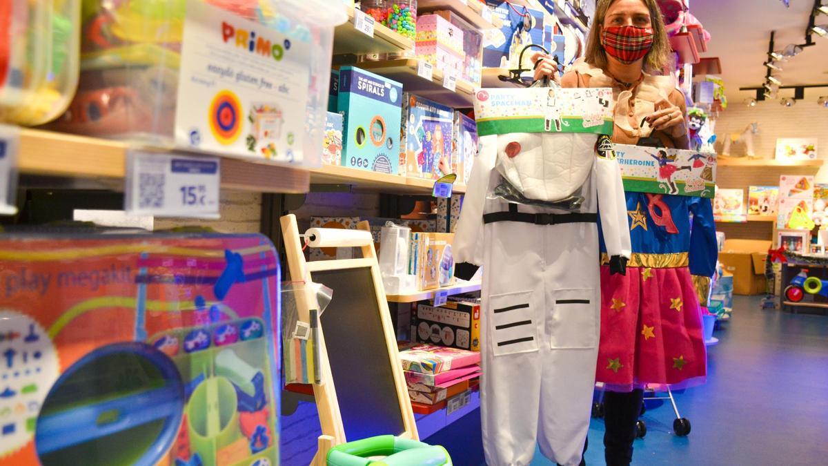 Paula  Palazón, de la tienda Imaginarium en Oviedo, muestra un disfraz de astronauta y otro de superwoman, muy demandados en estas fechas.