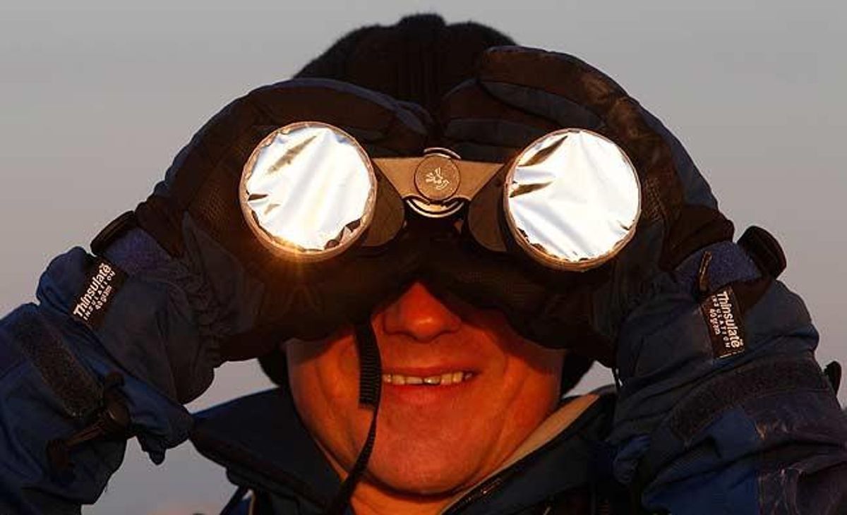 Un home observa amb binoculars l’eclipsi parcial de Sol a Viena.