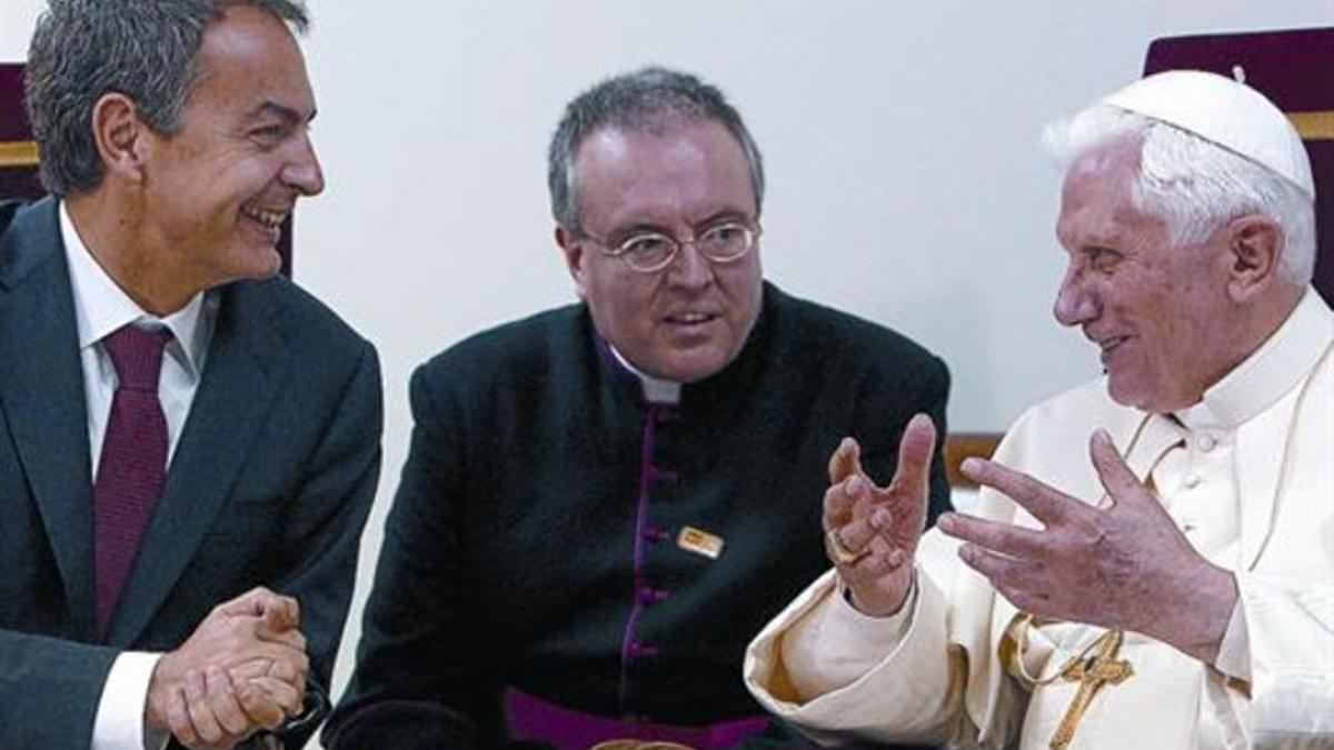 Zapatero y Benedicto XVI conversan, con ayuda de un intérprete, ayer en el aeropuerto de El Prat.