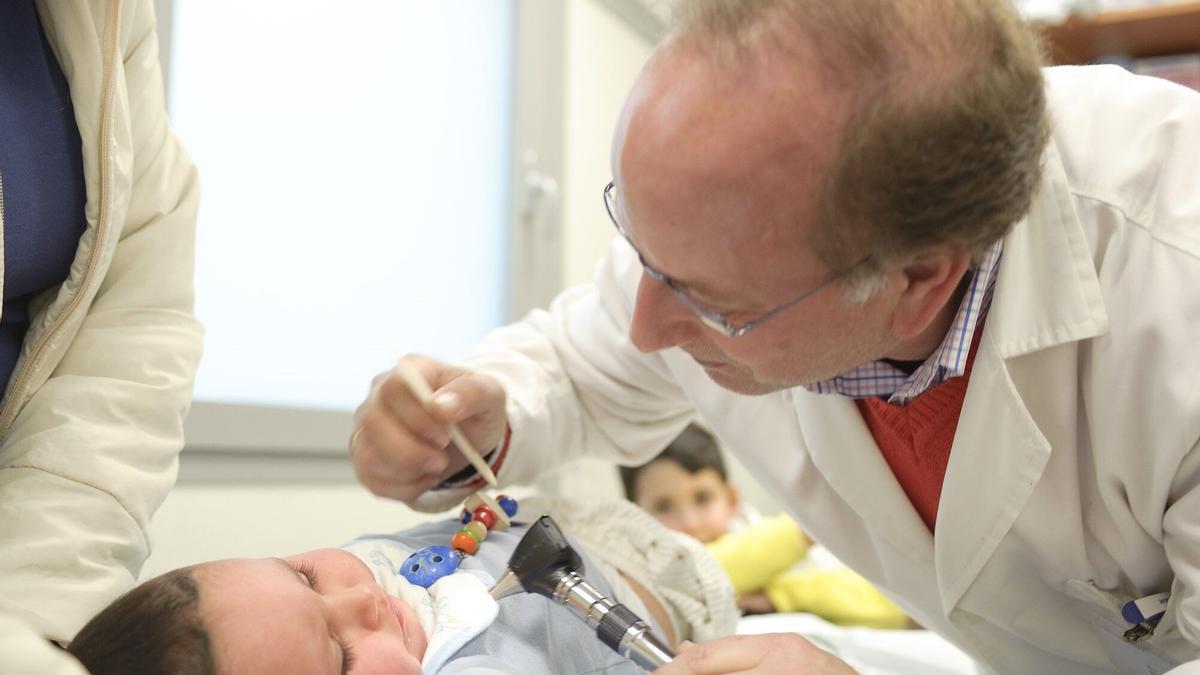 Un pediatra en consulta con un bebé.