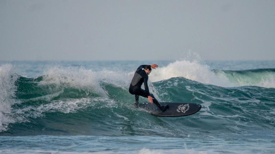 Un surfista prueba una de las tablas de Animal Surf, empresa asturiana que acaba de recibir apoyo del Principado por su talante innovador.