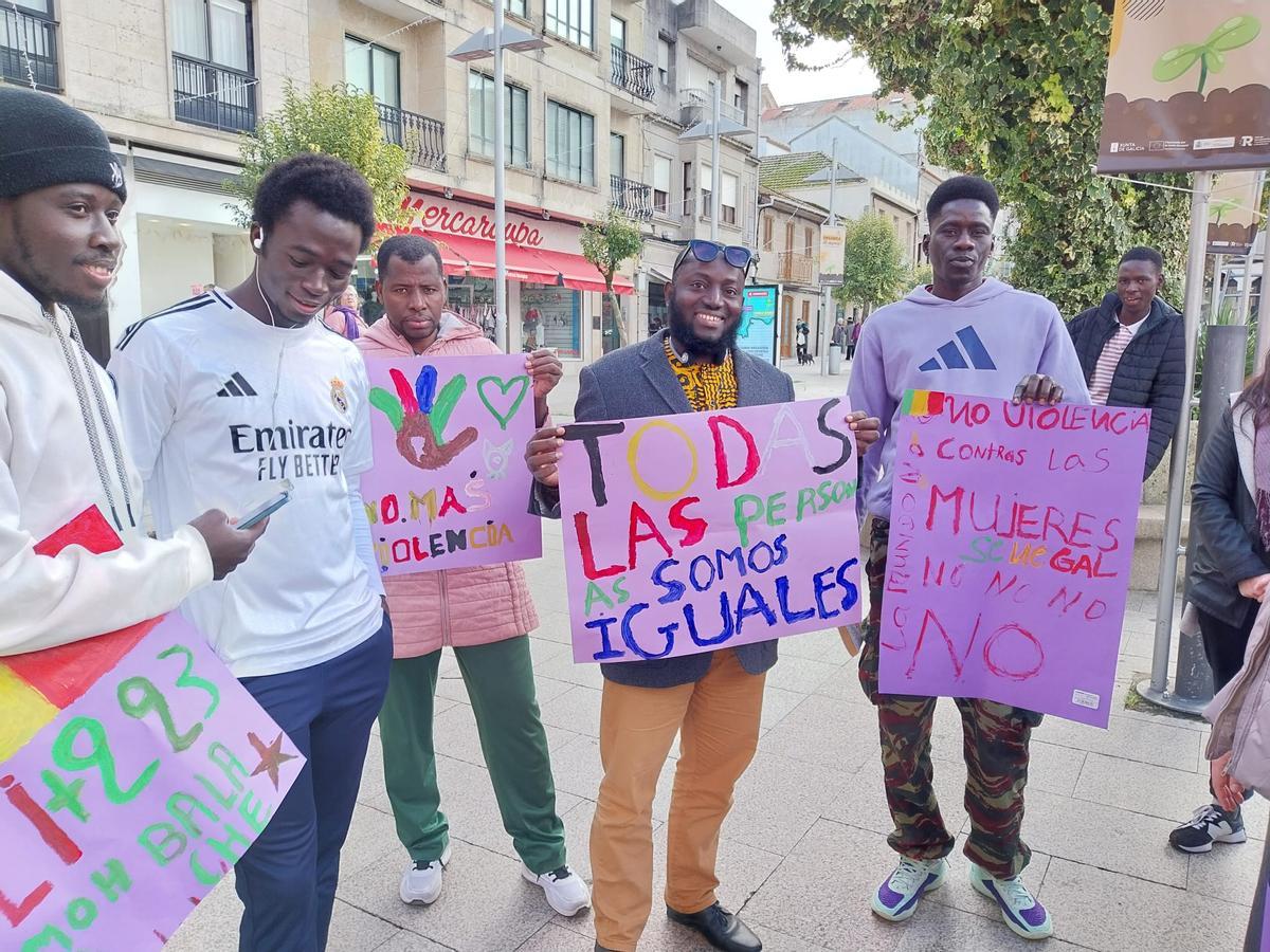 Algunos de los refugiados que están acogidos en Bueu durante la concentración de este martes con pancartas contra la violencia y a favor de la igualdad.