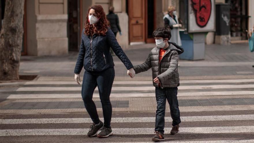 Una mujer camina con un niño en Valencia.