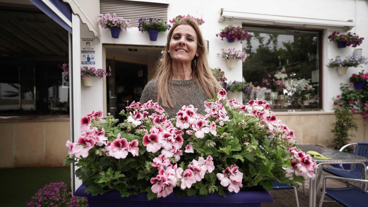 María Buenosvinos adorna con flores la terraza de su bar en Cañete.