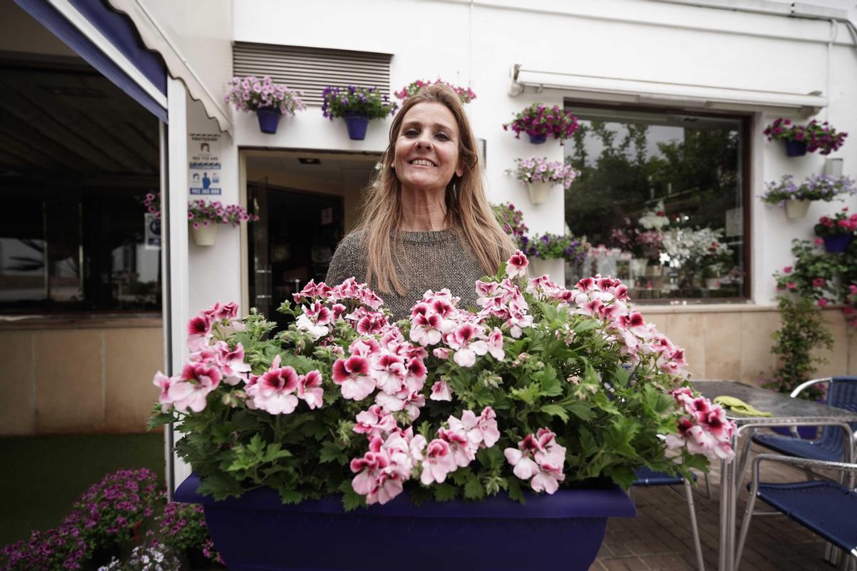 María Buenosvinos adorna con flores la terraza de su bar en Cañete.