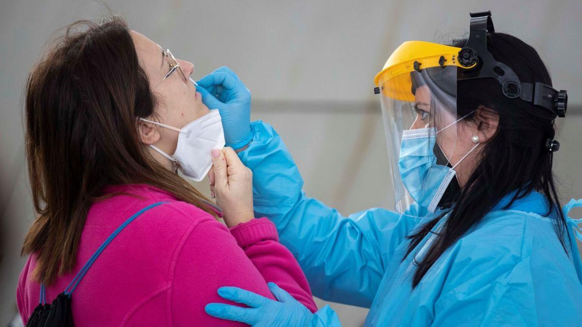 Una sanitaria realiza un test de antígenos a una maestra este domingo en un vivero de empresas de Murcia.