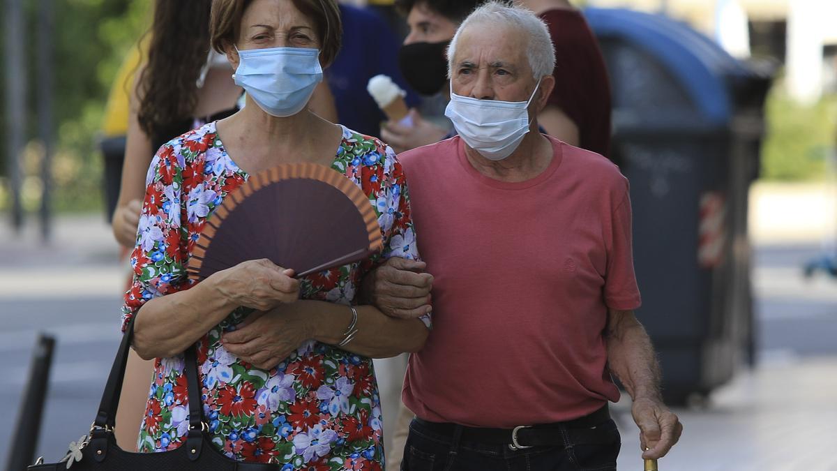 Una mujer usa el abanico para mitigar el calor