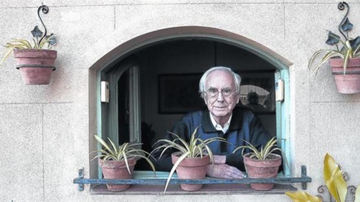Josep Maria Espinàs, asomado a la terraza de su casa.