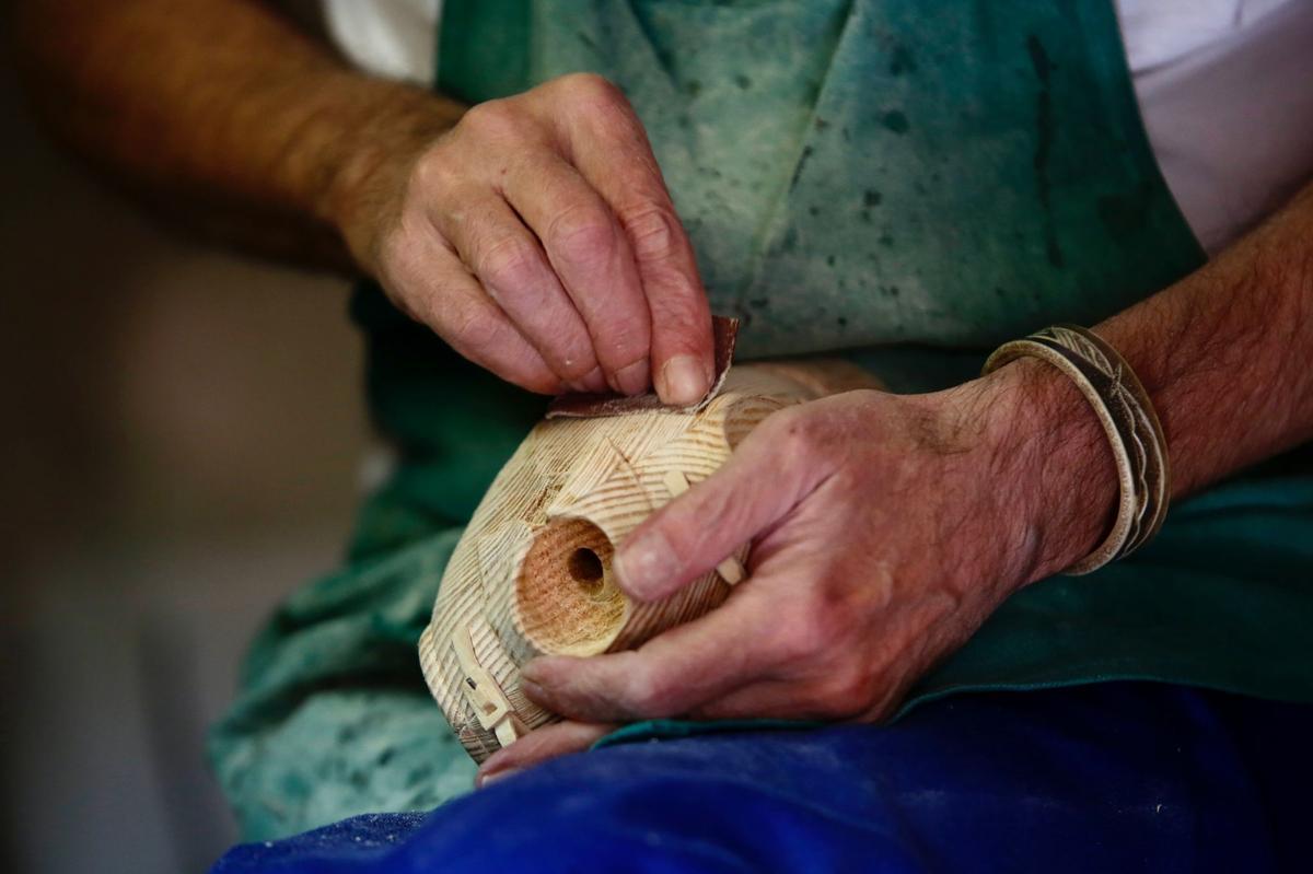 Las manos del escultor Ricardo Cane tallan el busto de una figura de madera