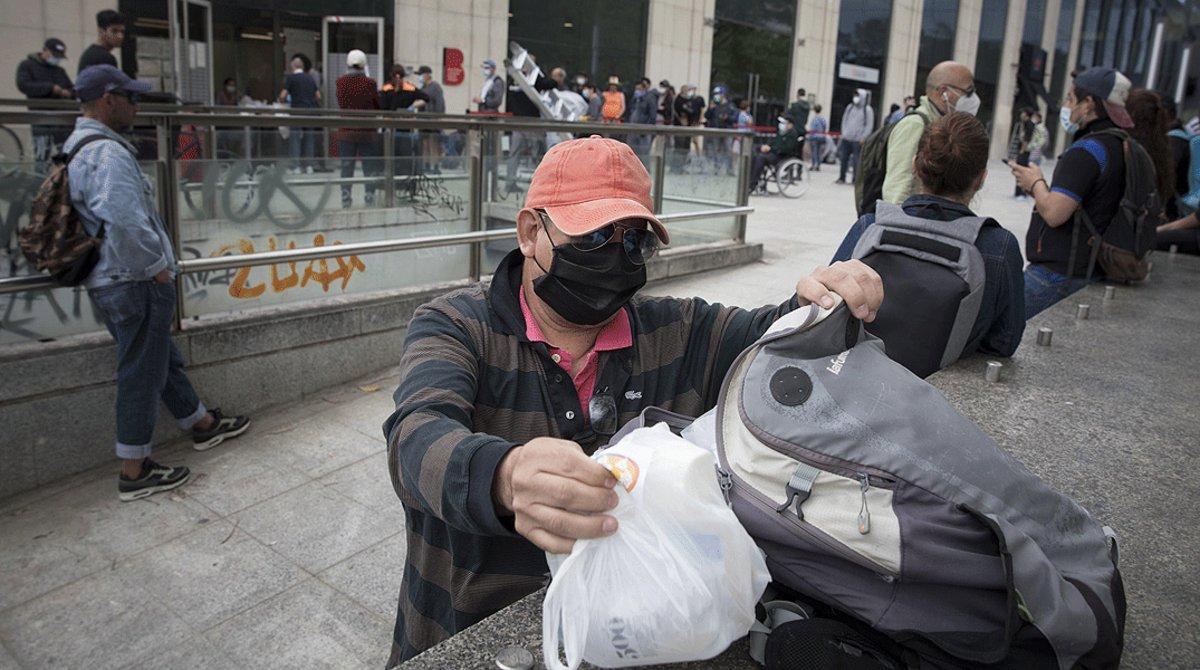 Cola para recoger artículos de primera necesidad que distribuye el Banc dels Aliments, en el SAIER de Barcelona, el 9 de mayo.