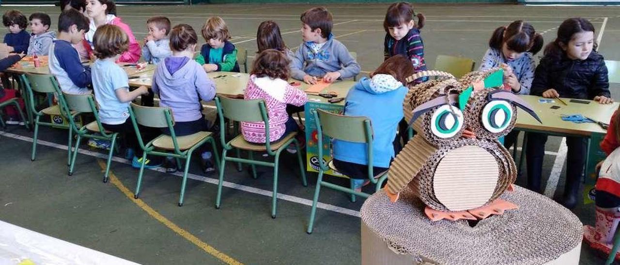 Los niños se afanan en hacer un búho como el modelo que aparece en primer término.