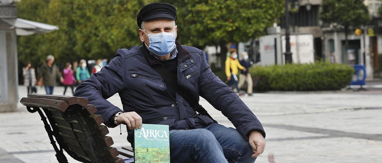 Francisco Isern, en el paseo de los Álamos (Oviedo) con su libro.