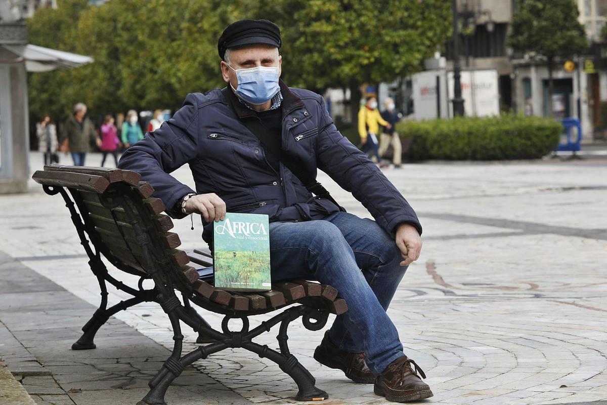 Francisco Isern, en el paseo de los Álamos (Oviedo) con su libro.