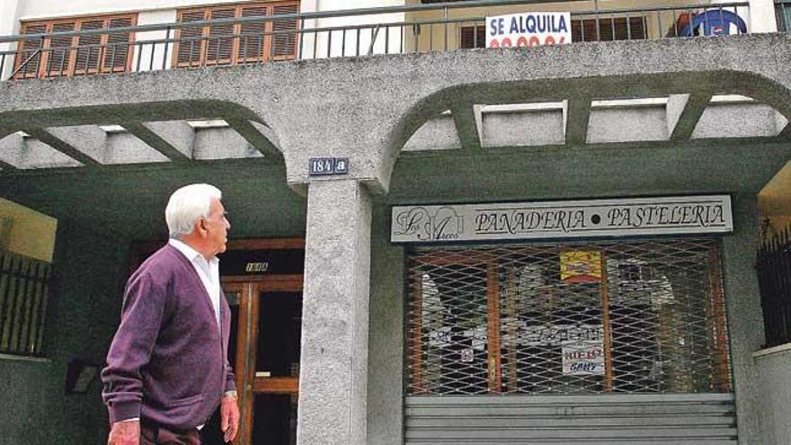 Un ciudadano observa desde la calle el cartel de una vivienda en alquiler.