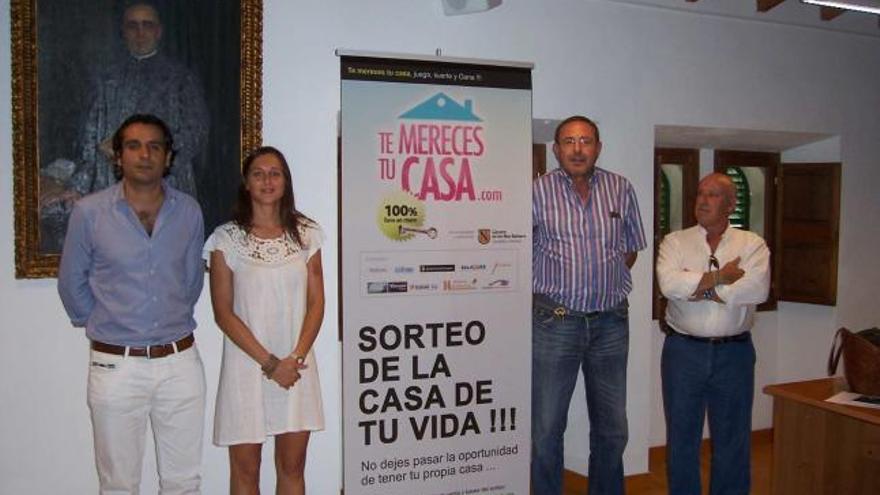 El alcalde de Campanet, a la izquierda, con los promotores ante un cartel del sorteo.