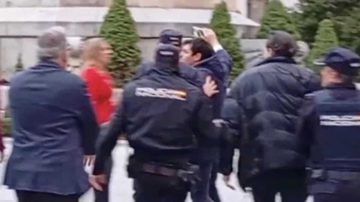 Captura de uno de los vídeos subidos por Quiles, en el que se ve a Briones, de rojo, tratando de impedir su acceso a Santaolalla.