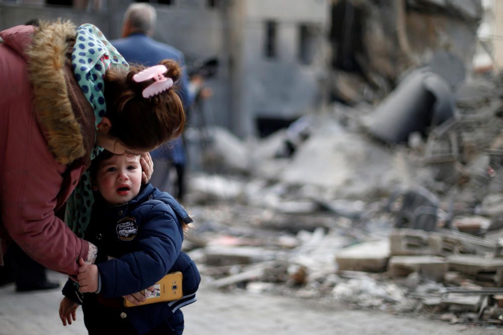 Palestinian woman comforts her son outside their ...