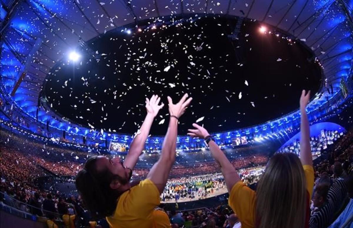 Espectadores celebrando la inauguración de los Juegos Olímpicos en el estadio de Maracaná