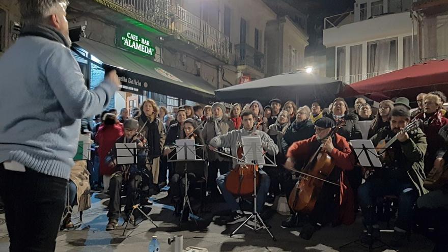 El Coro San José, rodeado de público en sus actuaciones por el centro urbano de Cangas. |   // FDV