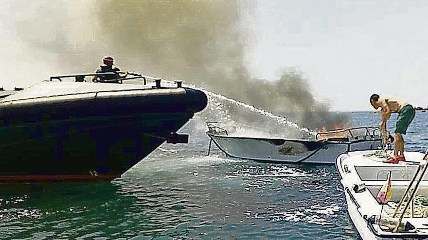 Agentes de la Guardia Civil del Mar sofocan las llamas.