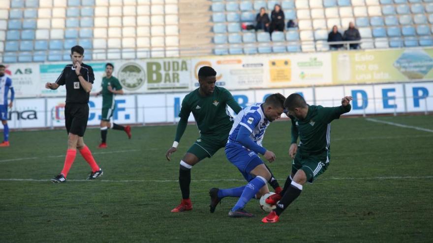 El jugador local Andrés Carrasco, autor de un tanto ayer, trata de marcharse de dos rivales.