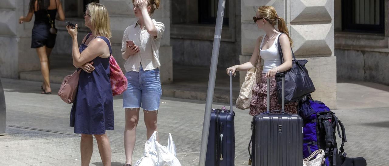 Turistas con maletas por el centro de Palma en busca de su alojamiento turística en una casa particular. | B.RAMON