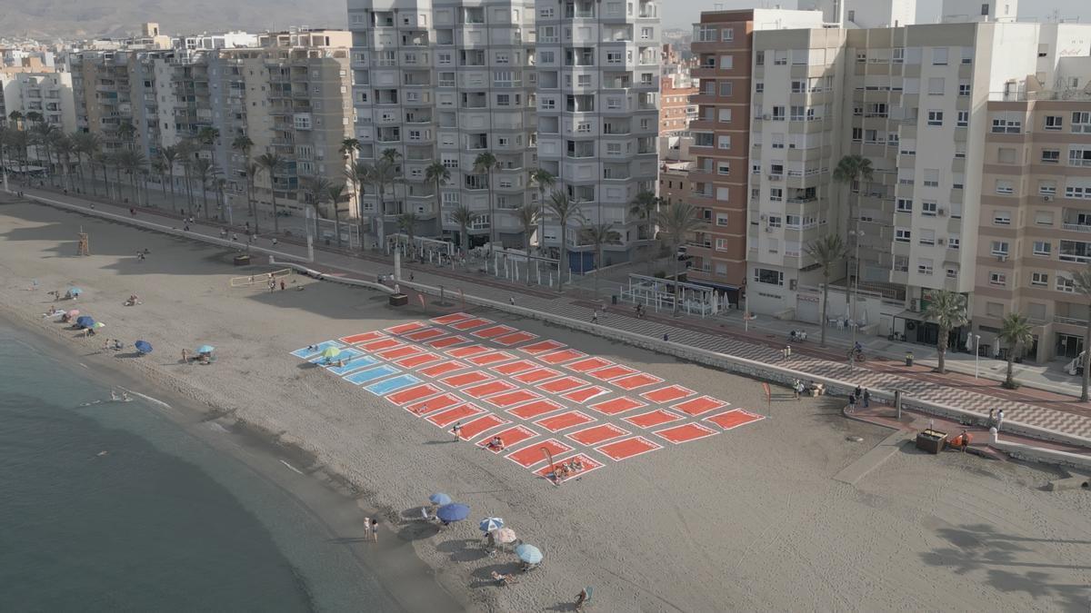 ●	La playa ha amanecido con este peculiar “parking” de 1.577 m², formado por 50 toallas de 5 x 3 metros que emulan plazas de estacionamiento.