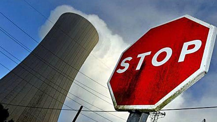 Señal de stop junto a la chimenea de una central térmica.