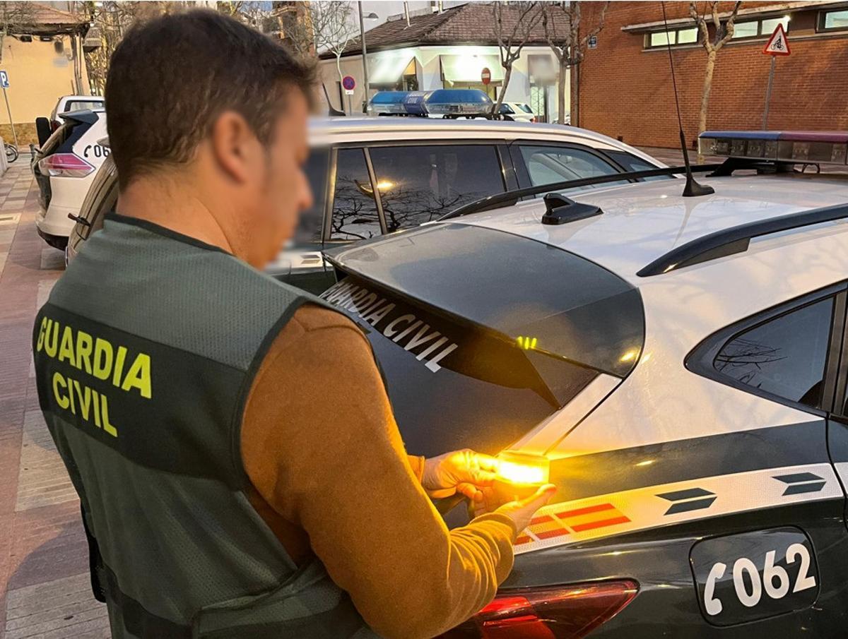 Un agente de la Guardia Civil sostiene una baliza.