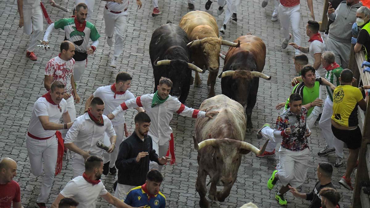 Los participantes corren delante de los toros durante el encierro el primer día de las fiestas de San Fermín en Pamplona.