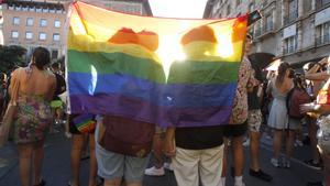 Dos personas con una bandera durante una manifestación por el Orgullo LGTBI.