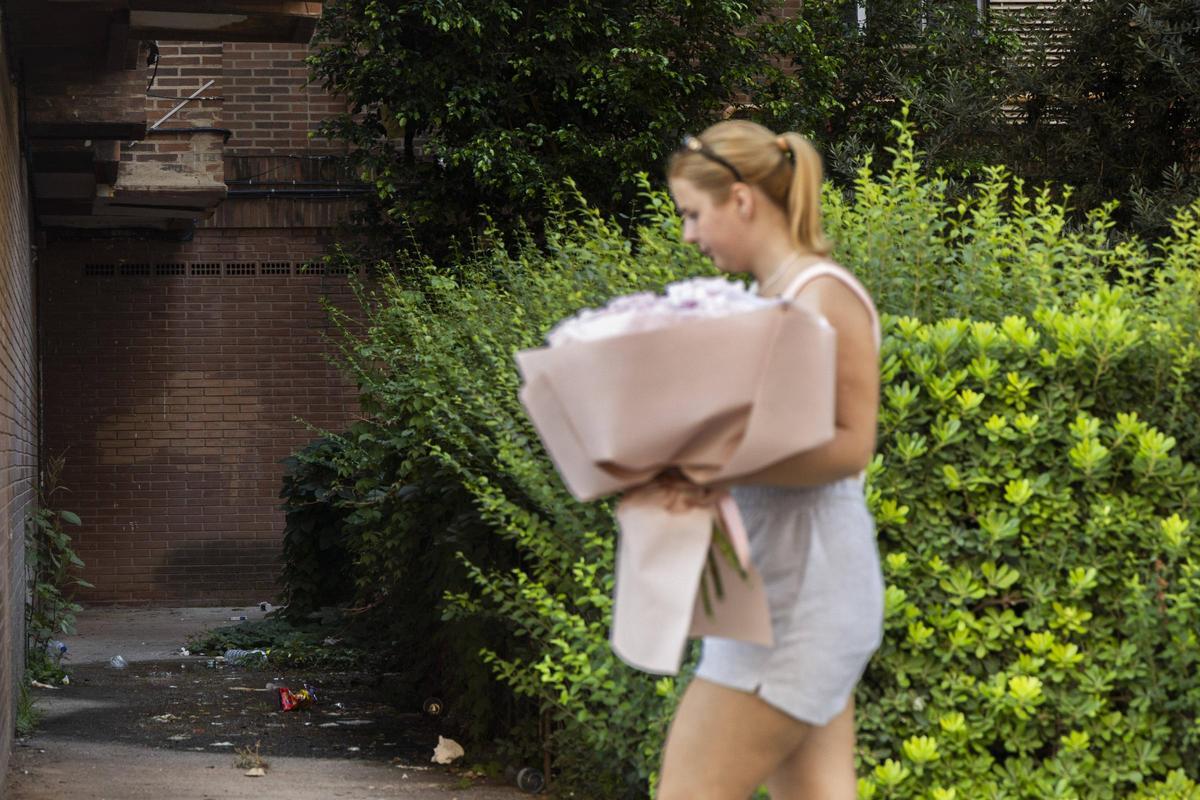 Una mujer camina por una calle de València, con suciedad al fondo.