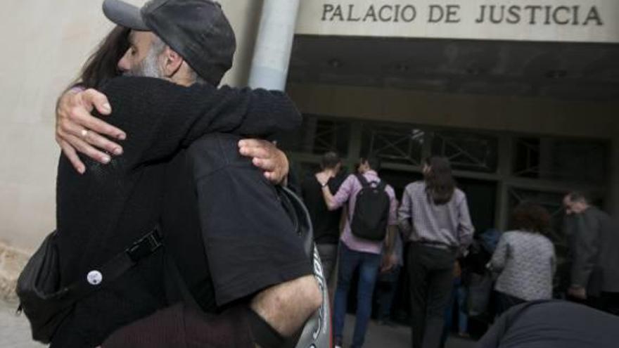 Uno de los acusados recibe un abrazo ayer momentos antes de que comenzara la vista.