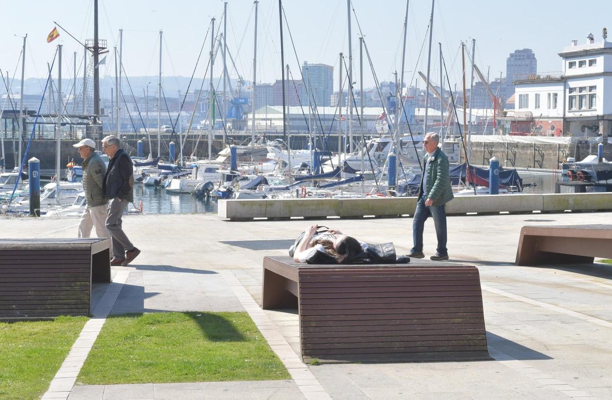 Viandantes disfrutan de un día soleado en A Coruña.
