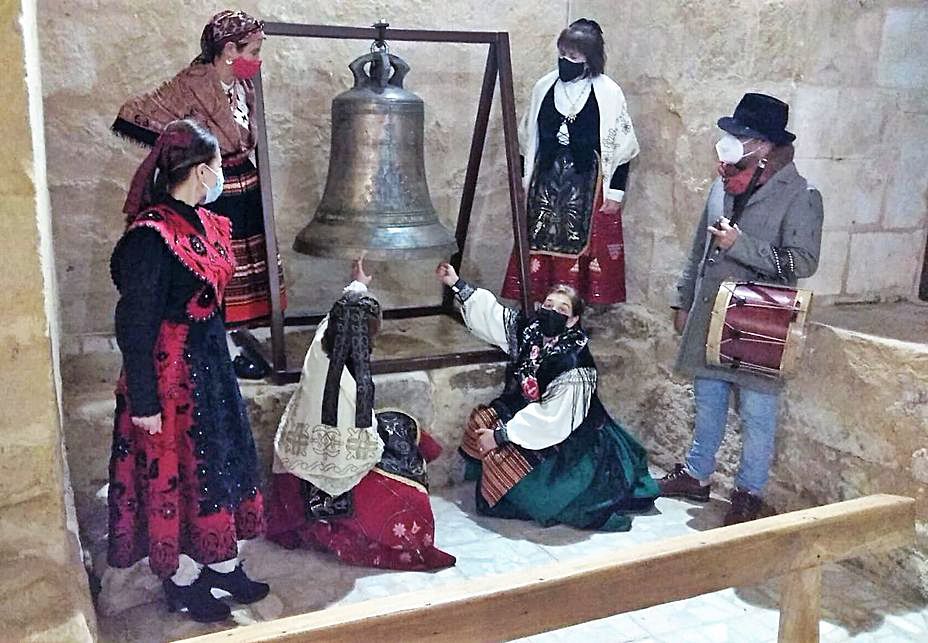 Las águedas de Fuentespreadas, junto a la campana expuesta en la iglesia.