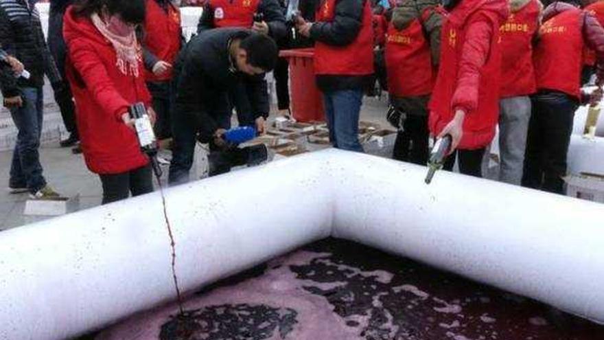 Operarios de la distribuidora, arrojando el vino en la balsa.