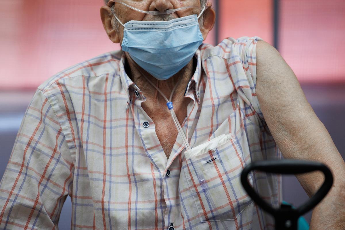 Un anciano prepara su brazo para la inyección de la dosis Moderna durante el inicio de la administración de la cuarta dosis de la vacuna frente al COVID-19 a los usuarios y trabajadores sociosanitarios de residencias.