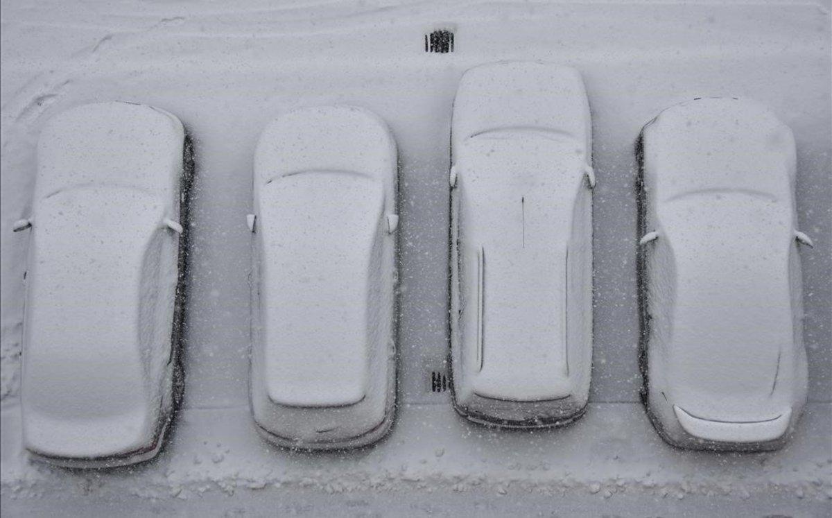 Coches aparcados cubiertos de nieve en Bratislava, Eslovaquia.