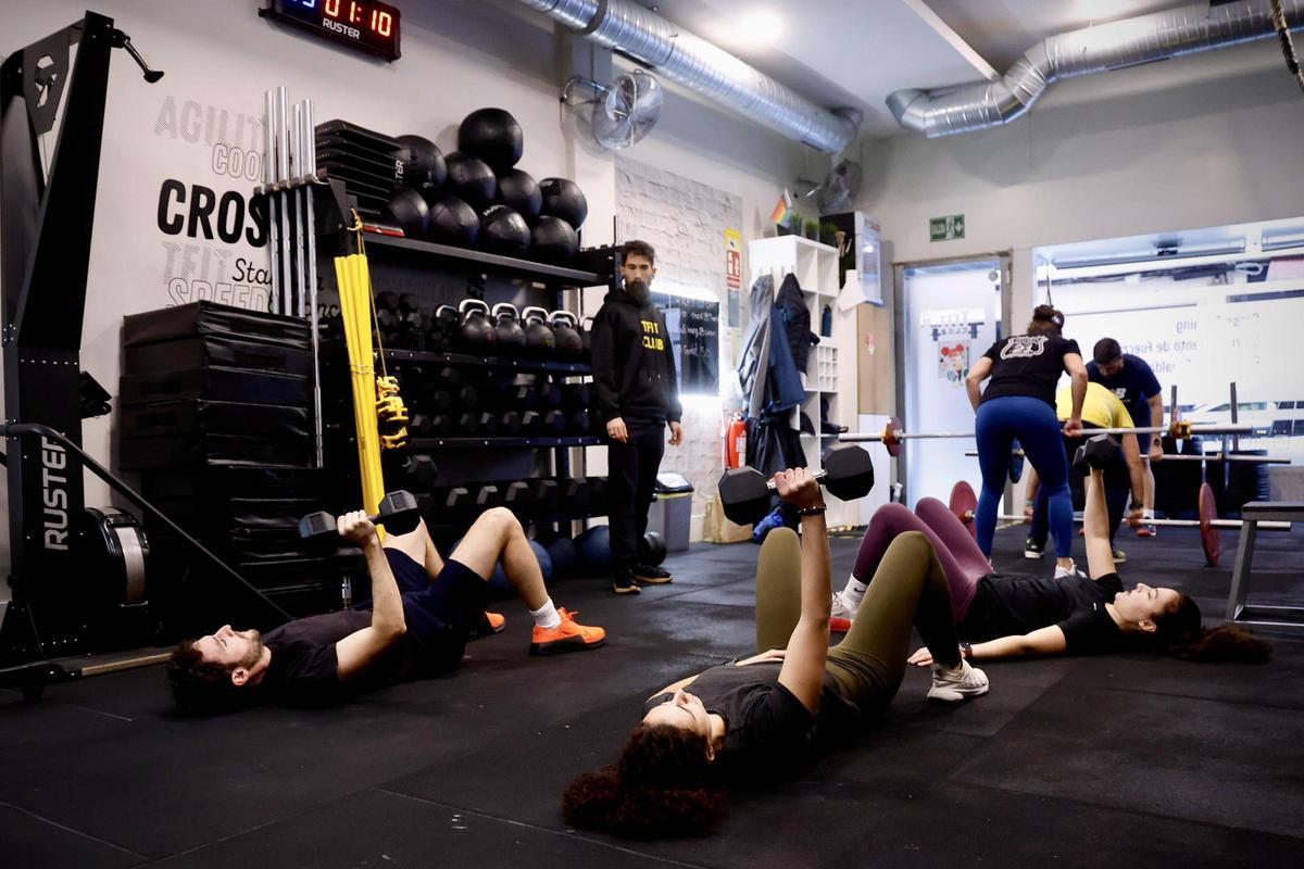 Clientes del centro TFiT club durante una clase con pesas.