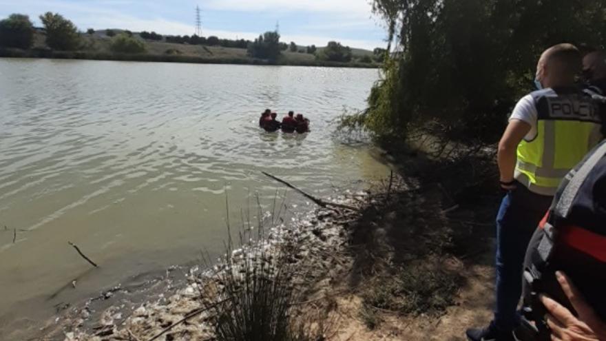 Los bomberos, en el momento del rescate del cadáver en el río.