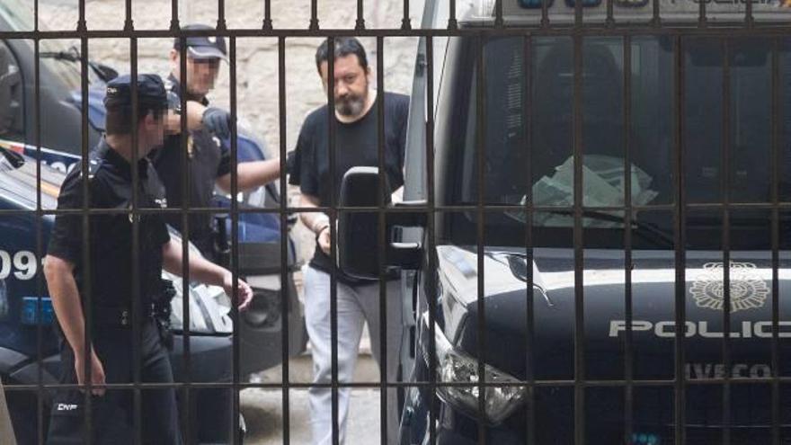 El acusado del triple crimen sale ayer detenido de los juzgados para ingresar en prisión.