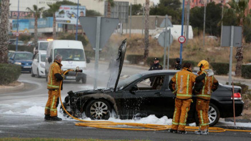 Los bomberos sofocan las llamas del vehículo en plena rotonda