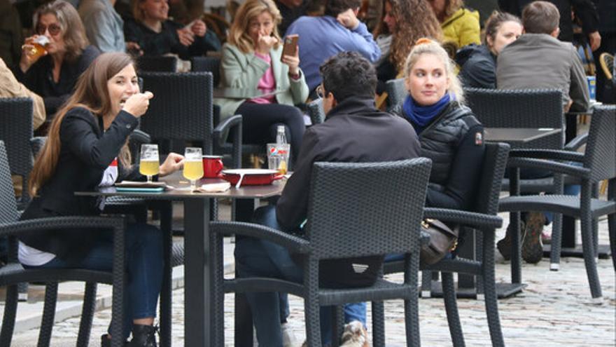 Uns joves en una taula a la terrassa d&#039;un bar de Girona