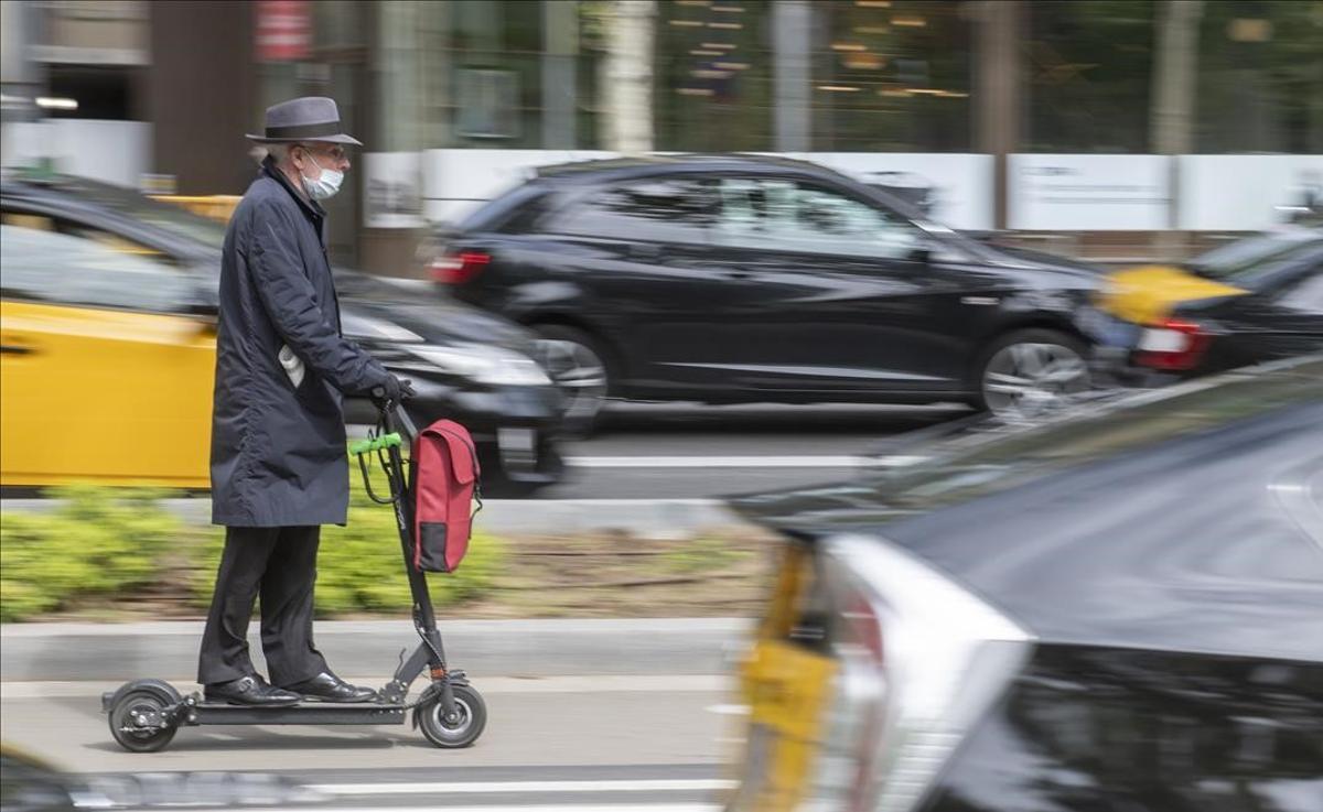 Un hombre circula con su patinete por el carril bici de la avenida Diagonal de Barcelona.