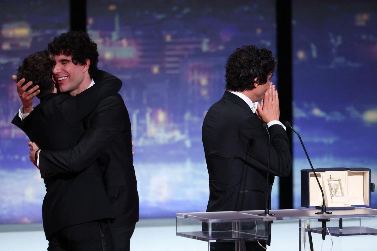 Javier Calvo (C) abraza al cineasta canadiense Xavier Dolan junto a Javier Ambrossi (D) sobre el escenario tras ganar ex aequo el premio a la mejor dirección por la película 'La Bola Negra' durante la ceremonia de clausura de la 79ª edición del Festival de Cannes, en Cannes, sur de Francia, el 23 de mayo de 2026.