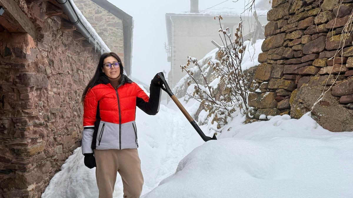 Clàudia Castaño, una de las dos personas que vive permanentemente en Rubió, quita la nieve con una pala.
