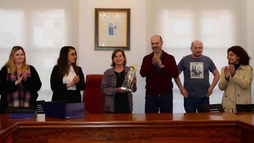 Toñi Vicente (centro), con el obsequio entregado por el alcalde (dcha.), ante ediles y hosteleros. Abajo, en la presentación de su libro “A miña cociña”. |   // G.N.